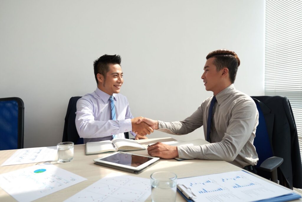 asian men handshaking after a business meeting in the office